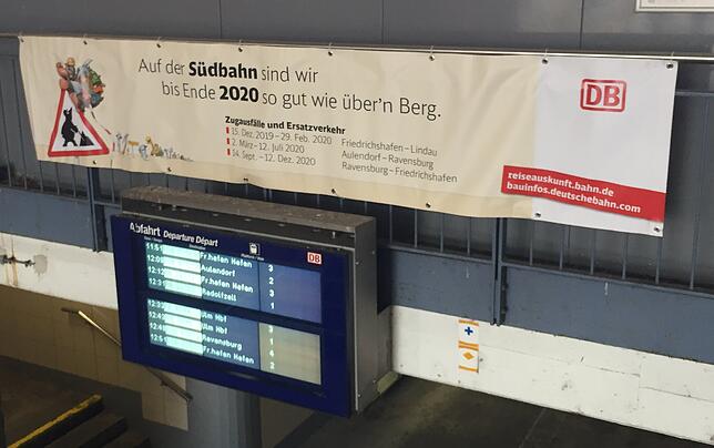 „Auf der Südbahn sind wir bis Ende 2020 so gut wie über‘n Berg“, heißt es auf einem Banner am Bahnhof Friedrichshafen.