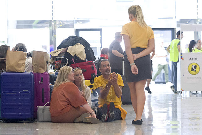 Mitarbeiter des Reisekonzerns Thomas Cook sprechen mit betroffenen Passagieren am Flughafen in Palma De Mallorca