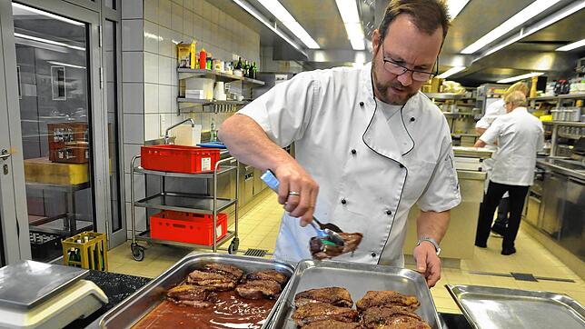 Marc Bernauer bereitet die fertig gebratenen Gänsebrüste für die Kühlung vor.
