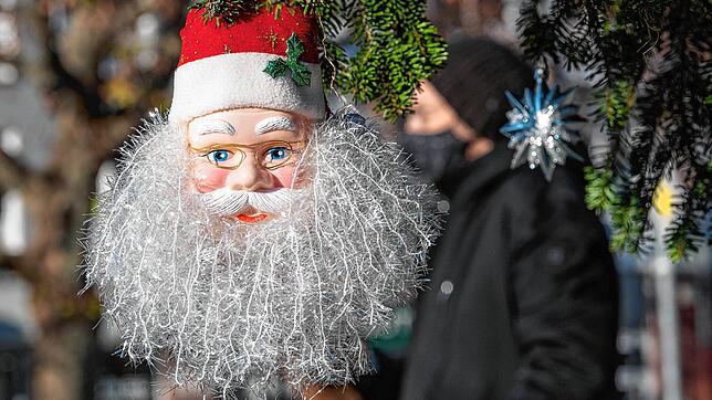 Ein Passant mit Mund- und Nasenmaske geht hinter einem Weihnachtsmann in Stuttgart vorbei. Baden-Württemberg geht in den harten ...