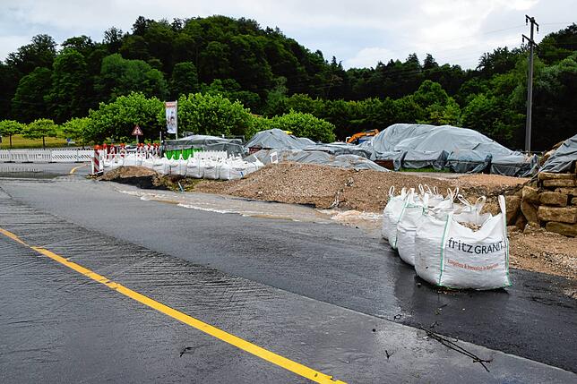 Die Sandsäcke gehören zu den neuen Sicherungen. Die Straße ist seitlich stärker geschützt und der Graben hinten mit Asphalt befestigt.
