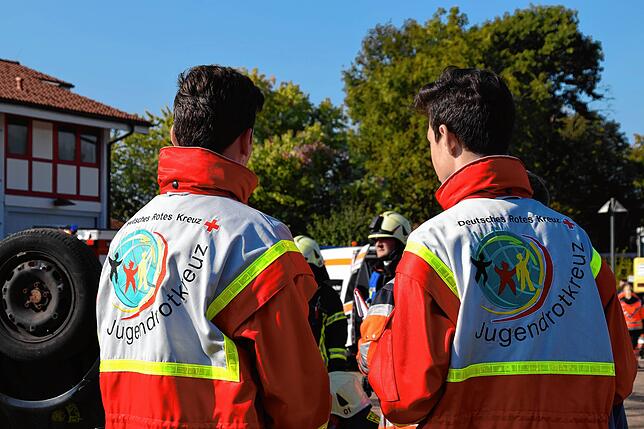 Der ehrenamtliche Nachwuchs vom Jugendrotkreuz beobachtet den hauptberuflichen DRK-Nachwuchs und die Feuerwehr beim Training.