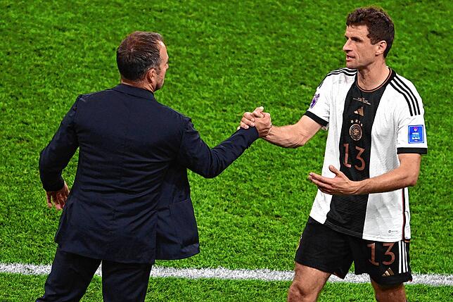 Trainer Hans-Dieter Flick schlägt mit Deutschlands Thomas Müller bei dessen Auswechslung ein.