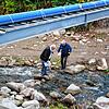 Theo Merz (links) und Alfred Scheuble überqueren mangels Brücke auf unkonventionelle Art die Schlücht.