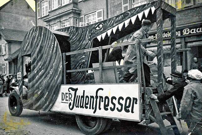 In der Arbeiterstadt Singen wird 1939 dieser Wagen präsentiert: „Der Judenfresser“ vertilgt die letzten noch nicht vertriebenen Jüdinnen ...
