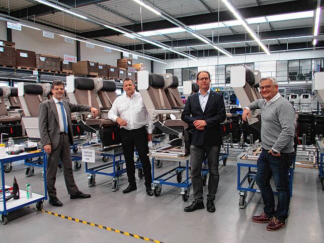 Auf Besuch in der Flugsitz-Produktion: Auch Markdorfs Bürgermeister Georg Riedmann (links) und Stadtkämmerer Michael Lissner (rechts) ...