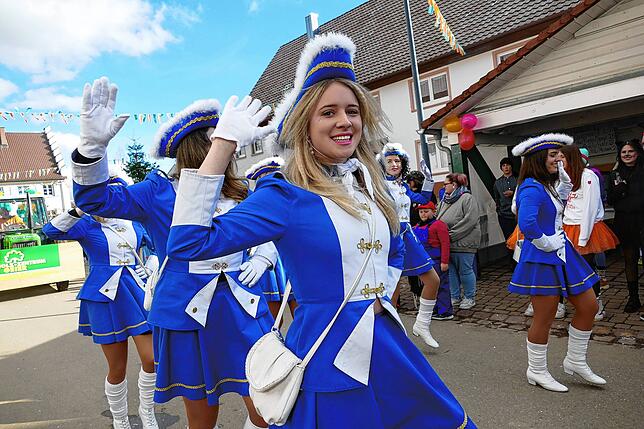 Uniform in blau-weiß und ein Lächeln auf den Lippen: Die Funkengarde grüßt die Narren beim Ewattinger Umzug.