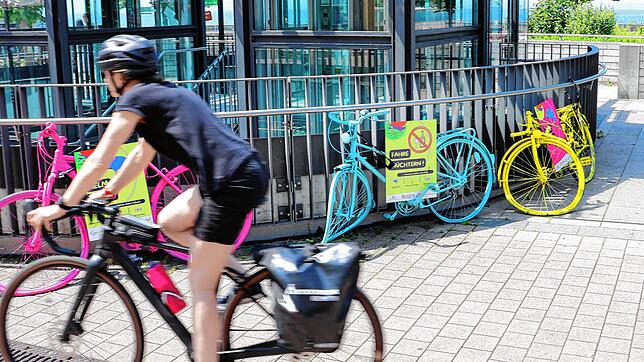 Eine Radfahrerin fährt an den „Crash Bikes“ am Parkhaus am See vorbei.