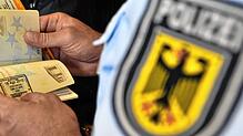 (Symbolbild) Ein Bundespolizist kontrolliert einen Ausweis. Das ist eine der Hauptaufgaben der Beamten. Immer wieder kommen sie dabei in ...