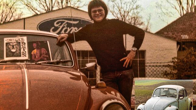 Rolf Wagner steht neben seinem ersten Käfer in orange; rechts zu sehen ist sein zweiter Käfer in blau.