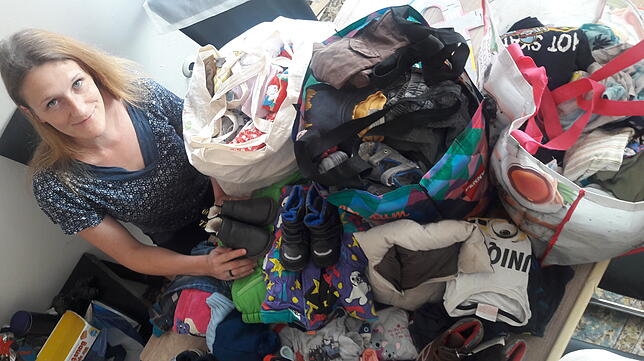Jede Menge Kinderkleidung, die nicht mehr gebraucht wird: Redakteurin Monika Olheide beim Packen.