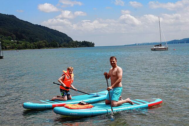 Der zehnjährige Jan Volke und sein Vater Patrick Paun liehen sich am Stand des Strandbads Ludwigshafen zwei Stand Up Paddle Boards (SUP) ...