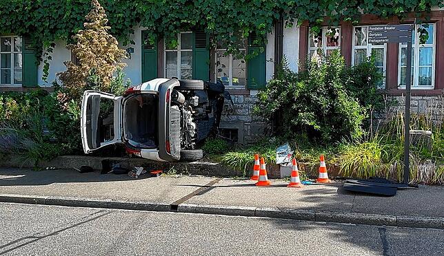 Mit geöffneter Heckklappe liegt das Auto auf der Seite.