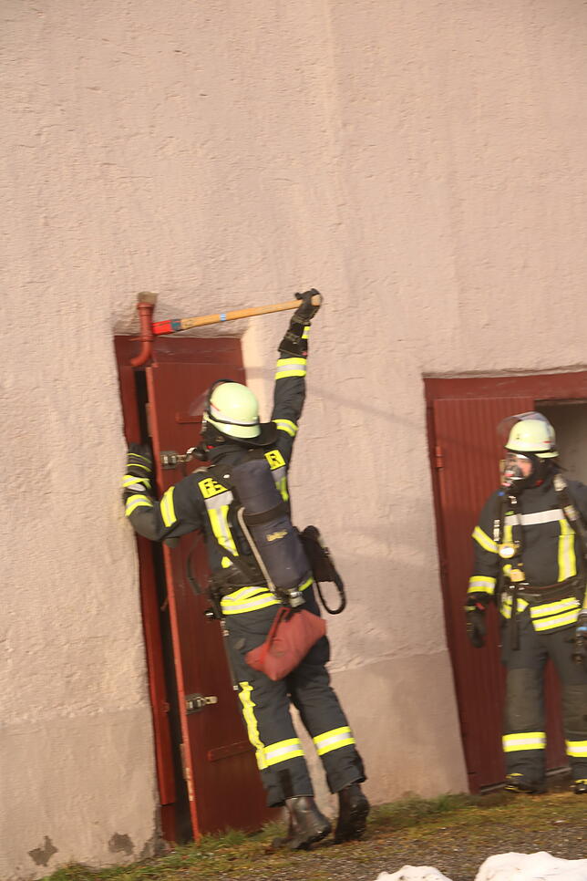 Feuerwehrleute verschaffen sich Zugang zum Ökonomieteil.