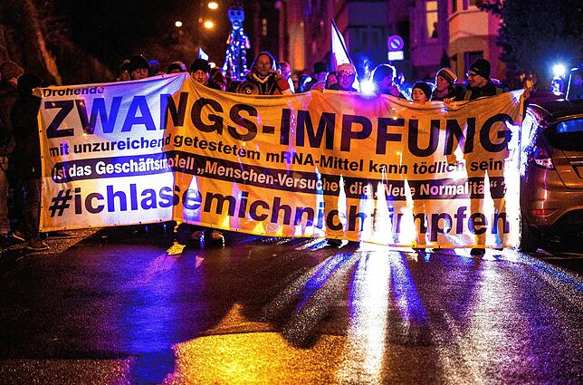 Menschen ziehen bei einer Demonstration gegen die Corona-Maßnahmen der Bundesregierung durch Stuttgart. Falschinformationen zur ...