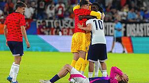 Deutschlands Nick Woltemade (unten) reagiert nach dem Schlusspfiff während Englands Spieler jubeln.