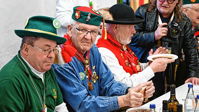 Winfried Kretschmann, Ministerpräsident von Baden-Württemberg (2.v.l), sitzt am Fastnachtsdienstag im Rathaus vor einem einen Teller ...