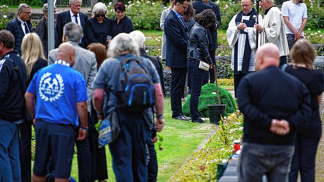 Trauernde stehen bei der Beisetzung von Sportreporter Ulli Potofski auf dem Schalker Fan-Feld auf dem Friedhof ...