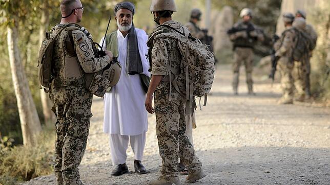 August 2011: Ein Bundeswehrsoldat (links) und ein afghanischer Dolmetscher (rechts) sprechen bei Kundus mit einem Mann.
