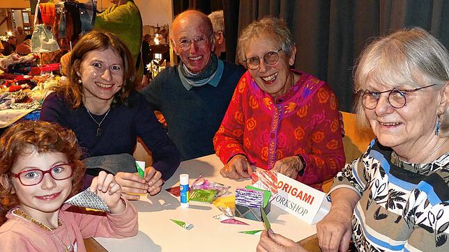 Am laufenden Band probieren sich Besucher beim Origami (von links): Mila, Cynthia sowie Erwin und Inge Rößler, die von ...