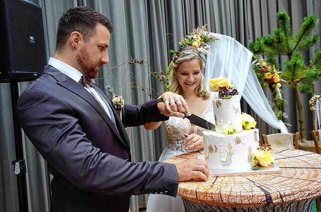 Das Brautpaar schneidet nach der nachgestellten Zeremonie die Hochzeitstorte an.