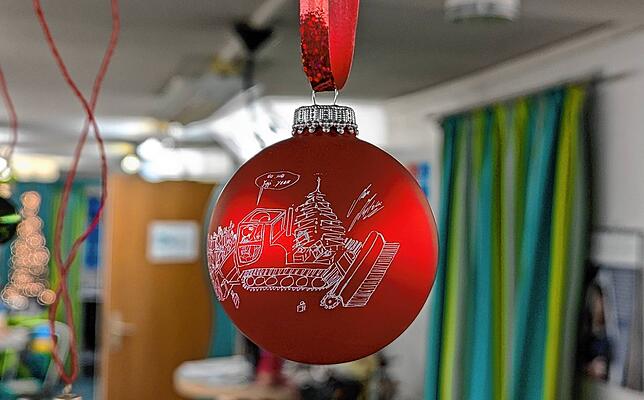 Die Weihnachtskugel zeigte eine Pistenraupe und einen Weihnachtsmann, der eine Vielzahl von Geschenken vor sich herschiebt.
