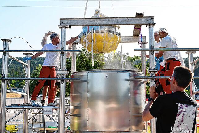 Der rohe Kloß wird mit einem Bagger in den 3000-Liter Kochtopf gehoben. Beim Dorfjubiläum haben die Wombacher einen Kartoffelkloß mit ...