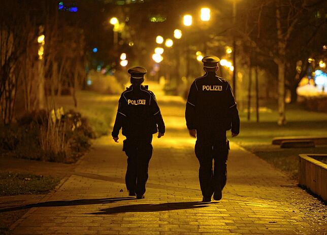 Polizisten laufen in der Nacht Streife und kontrollieren die Einhaltung der Ausgangssperre.