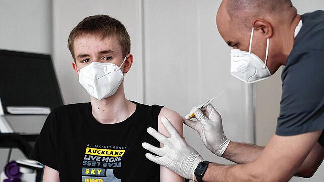 Ein 15-Jähriger wird in einer Arztpraxis in Nordrhein-Westfalen mit dem Impfstoff von Biontech/Pfizer geimpft. Unumstritten ist das ...
