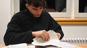 Wahlhelfer Pepe Leggio arbeitet sich durch die Stimmzettel der Briefwahl
