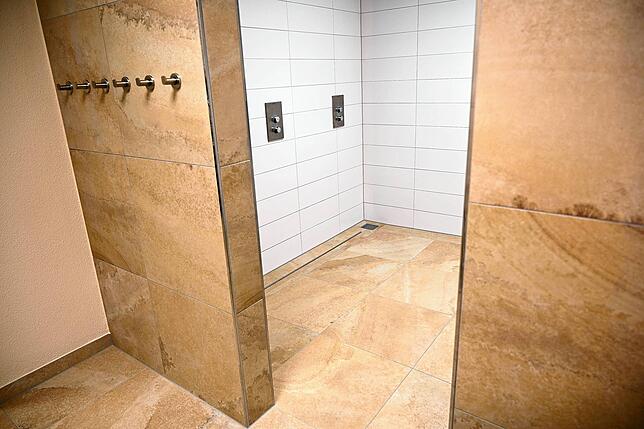 Neu gestaltet und erweitert wurden die Dusch- und Toilettenräume und mit Fliesen aus einem Solnhofer Natursteinimitat ausgestaltet.