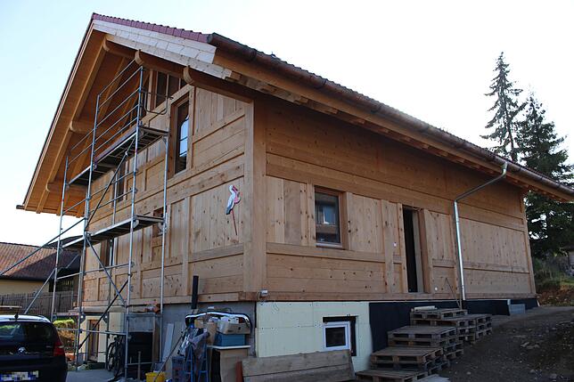 Die Fenster sind drin und die Familie wohnt bereits in ihrem Holzhaus. Jetzt fehlen noch einige Details. Etwa der Balkon auf der ...