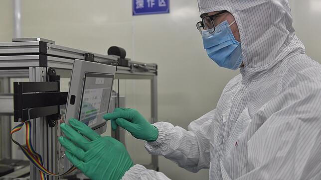 Ein Mitarbeiter bearbeitet einen Nukleinsäuretestchip in der Anlage eines Biotech-Unternehmens. Ein neu entwickelter ...