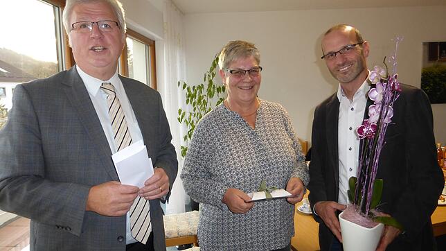 Erika Zwink wird von dem Vorsitzenden der Kirchlichen Sozialstation Reinhold Engesser (links) und Geschäftsführer Markus Leichenauer ...
