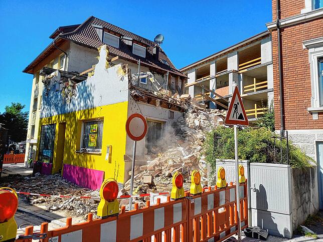 Immer wieder befördert der Minibagger auf der Erdgeschossdecke der Ruine Schutt nach unten. Es dröhnt und staubt.
