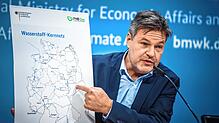 Robert Habeck zeigt bei der Vorstellung des Wasserstoff-Kernnetzes auf eine Deutschlandkarte. In Süd-Baden-Württemberg fehlen die Leitungen.