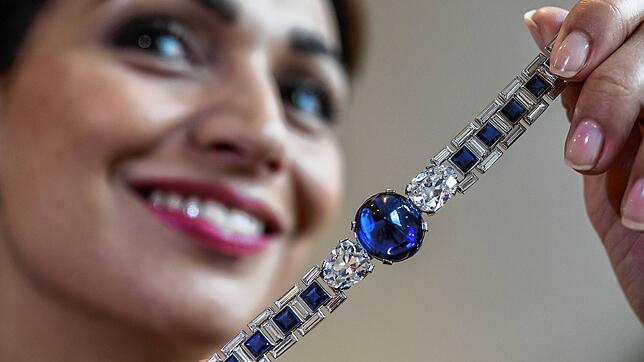 Eine Mitarbeiterin des Auktionshauses Sotheby‘s hält ein Armband mit einem Cabochon Saphir mit 46,07 Karat in der Mitte. Edelsteine als ...