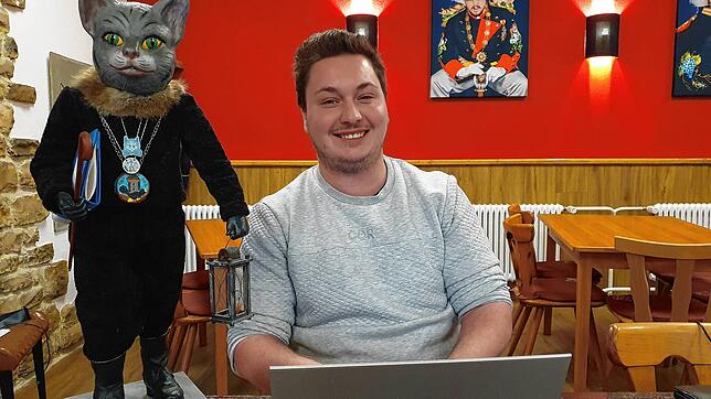 Stolz klopft der Kater Miau Niklas Klein auf die Schulter. Der Vereins-Schriftführer hat ein digitales Konzept fürs Jubiläums-Wochenende ...