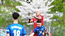 Luca Blum (rotes Trikot) gewinnt ein Kopfballduell im heiß umkämpften Derby in der Bezirksliga Schwarzwald.