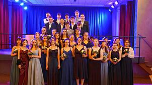 Die Neuntklässler stehen nach der Polonaise beim Abschlussball vor und auf der Bühne, um sich von ihren Familien fotografieren zu ...