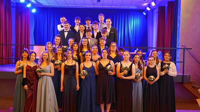 Die Neuntklässler stehen nach der Polonaise beim Abschlussball vor und auf der Bühne, um sich von ihren Familien fotografieren zu ...