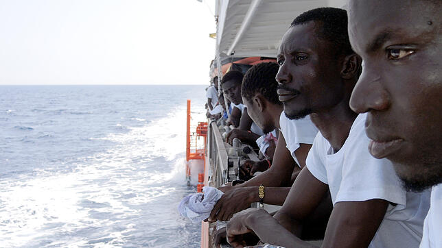 Charles Asamoah (Zweiter von rechts) aus Ghana blickt im Juni 2017 an Deck des Rettungsschiffs &bdquo;Aquarius&ldquo; auf das Mittelmeer.