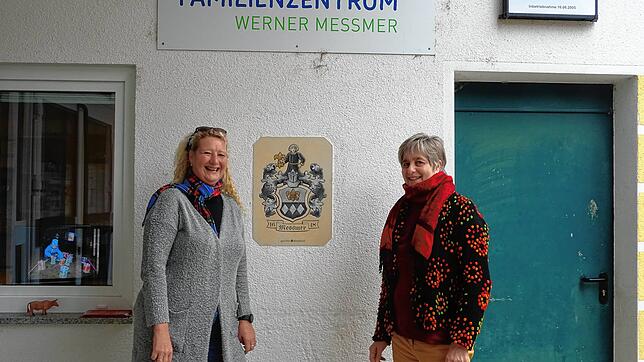 Martina Bender (links) und Dorothea Joos-Räuber (rechts) vor dem Eingang des Werner-Messmer-Kindergartens. Auf dem Monitor hinter dem ...