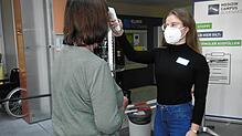 Im Dienst bei der Einlasskontrolle in den Kliniken des Medizin-Campus Bodensee: Bettina-Maria Kaupert misst die aktuelle Temperatur ...