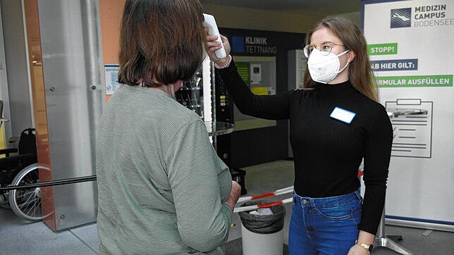 Im Dienst bei der Einlasskontrolle in den Kliniken des Medizin-Campus Bodensee: Bettina-Maria Kaupert misst die aktuelle Temperatur ...