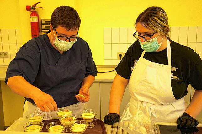 In Vorbereitung: Julia Holzmeyr und ihre Schülerin verteilen Haferkekse über dem Zitronen-Dessert.