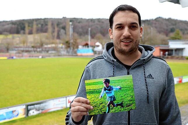 Florian Liebegott zeigt auf dem Sportgelände des FC Steißlingen ein Bild, das ihn als kleinen Jungen beim Fußball spielen für seinen ...