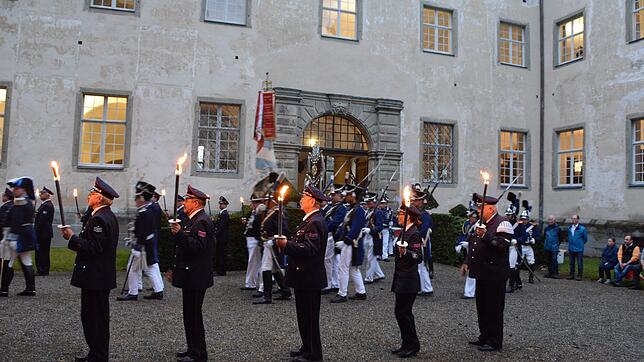 Villinger Feuerwehrleute stehen mit Fackeln Spalier, als die Historische Bürgerwehr Villingen in den Sternenhof von Schloss Salem ...