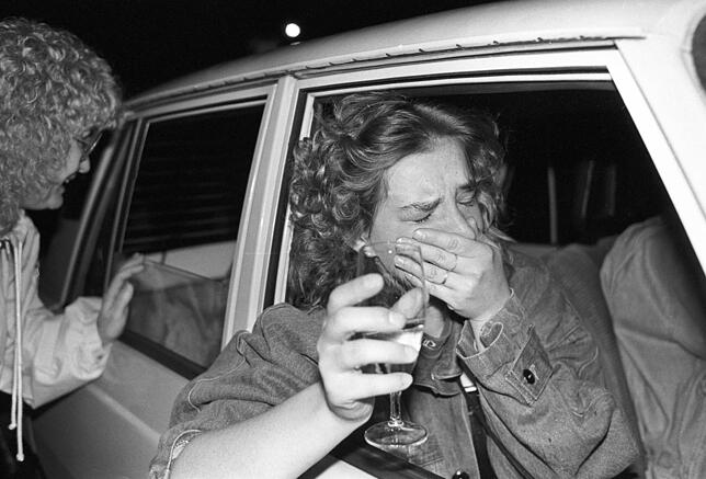 Es sind Bilder, die es nach dem Mauerfall in die Geschichtsbücher schafften. Eine Frau in einem Trabant hält ein Sektglas in der Hand ...