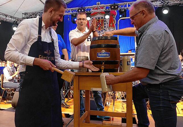 „Das Bier ist angezapft, lacht Bürgermeister Patrick Haas während artur Welte den ersten Maßkrug füllt. Ortvorsteher Volker Gut (Mitte) ...